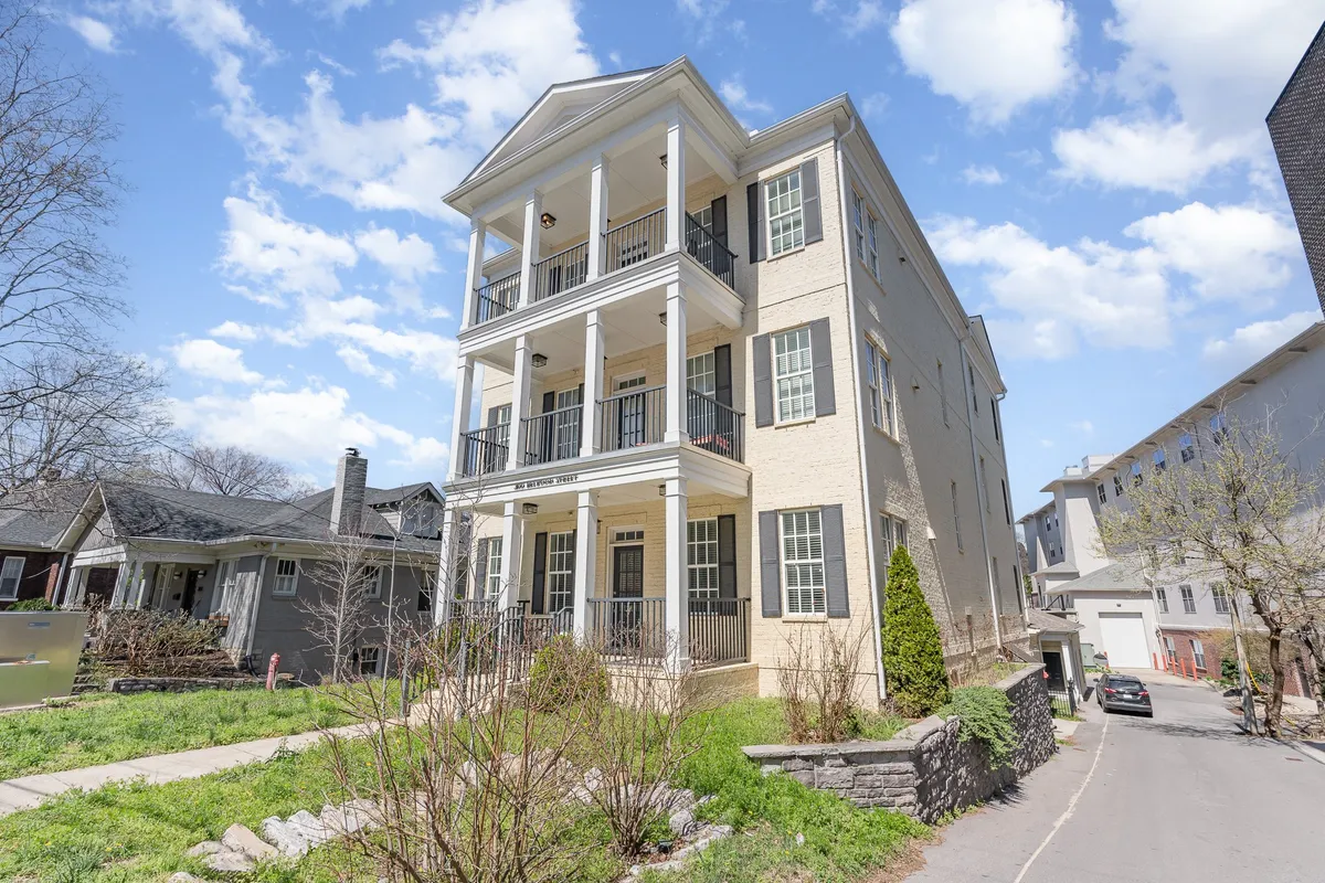 This image features the grand entrance of a stately building with columns and a balcony, giving a sense of welcome and sophistication. The overall structure and outdoor presence suggest a prime location in Midtown, ideal for business travelers arriving or networking.